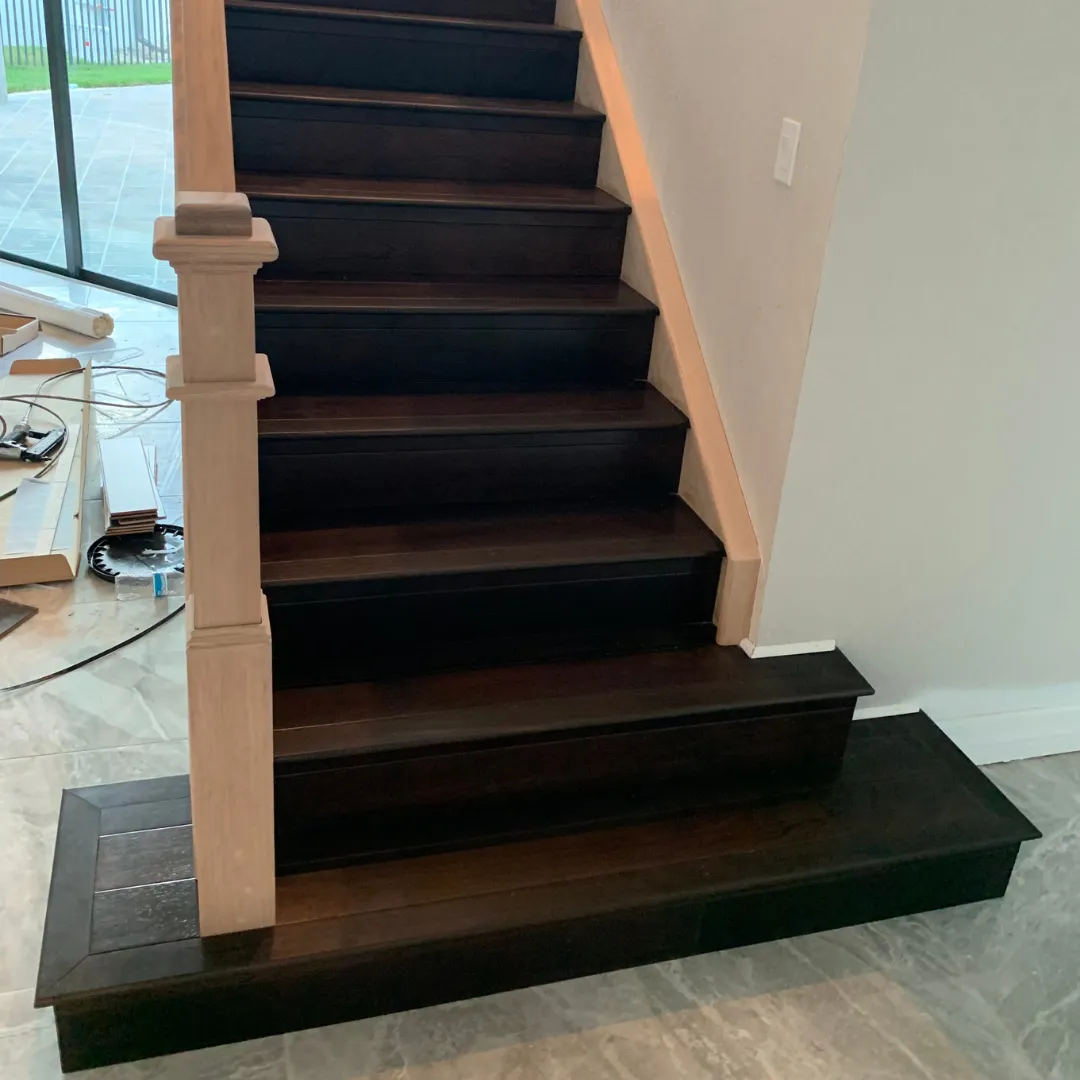 Dark stained hardwood staircase with custom newel post