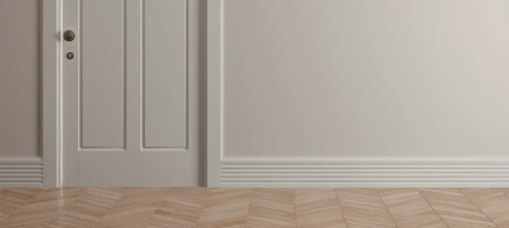 Light parquet wood flooring with white baseboard and door trim